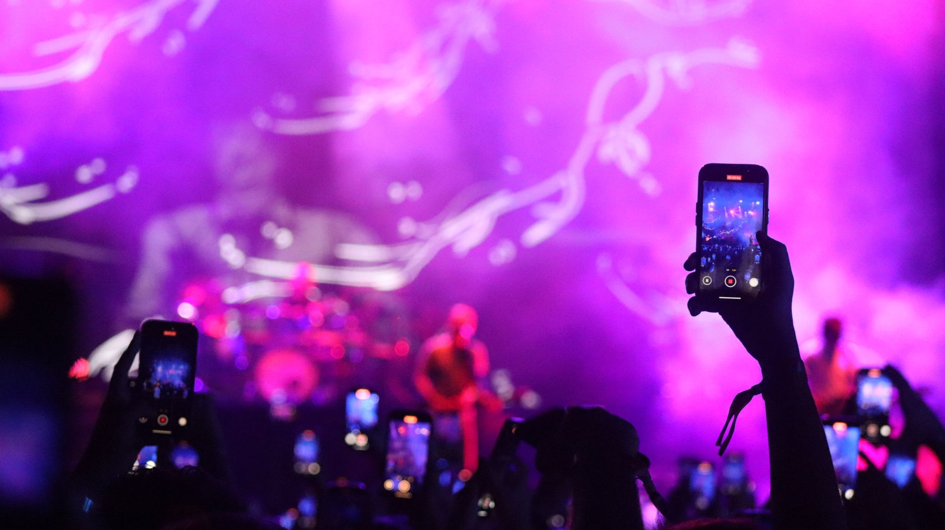 Concert stage washed in magenta and violet light at a Singapore event