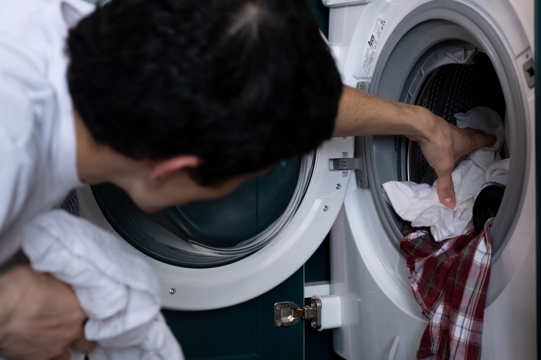 A Chillwash technician repairing a washing machine in a Singapore home