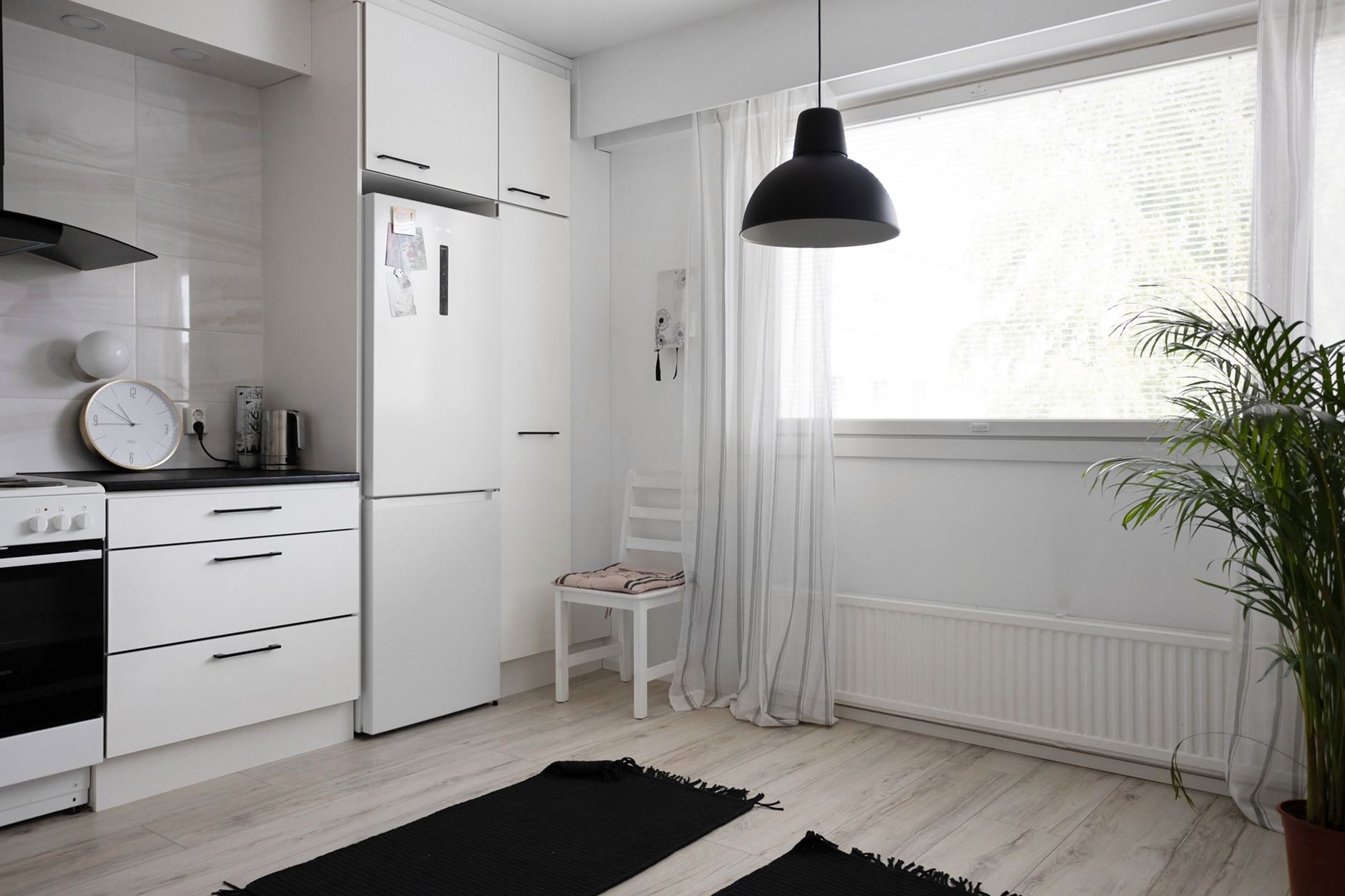 A bright modern Singapore kitchen with a refrigerator and built-in oven