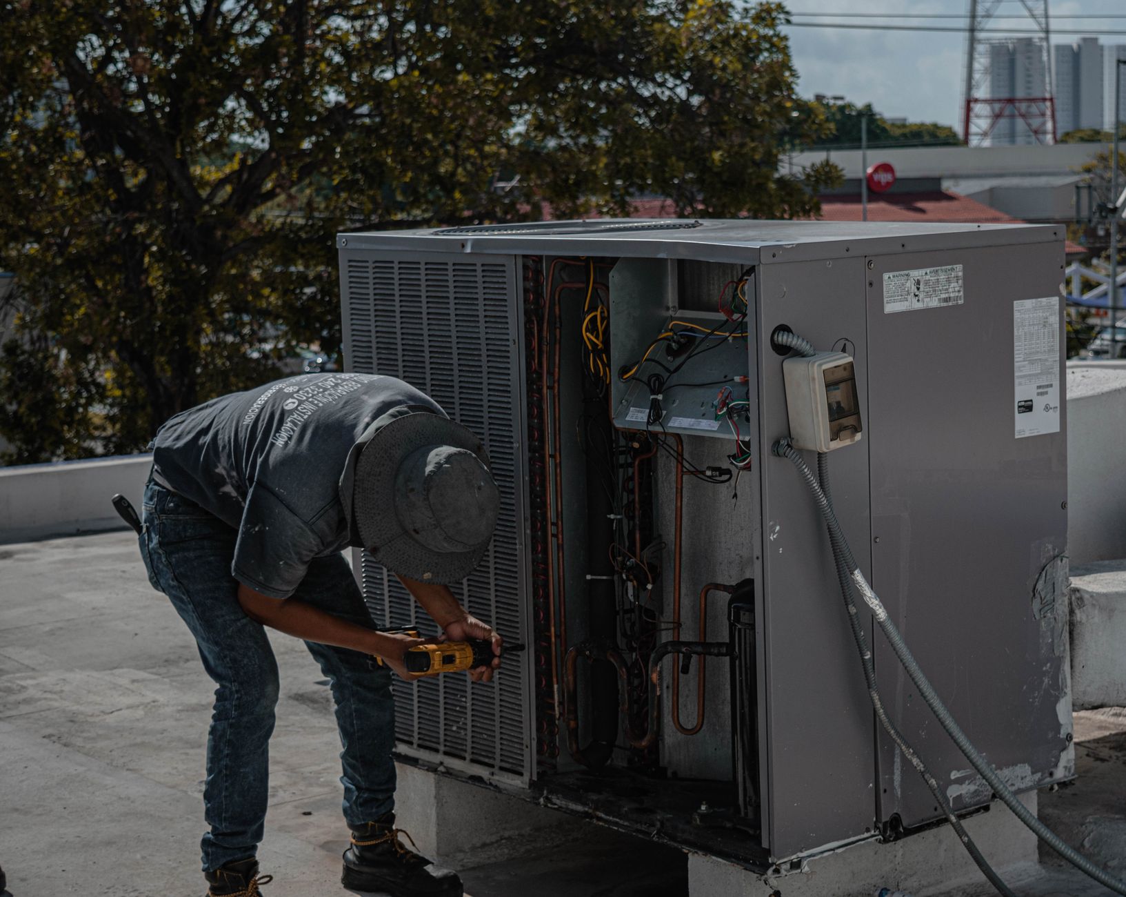 A Coolworks installer mounting an aircon unit in a Singapore flat