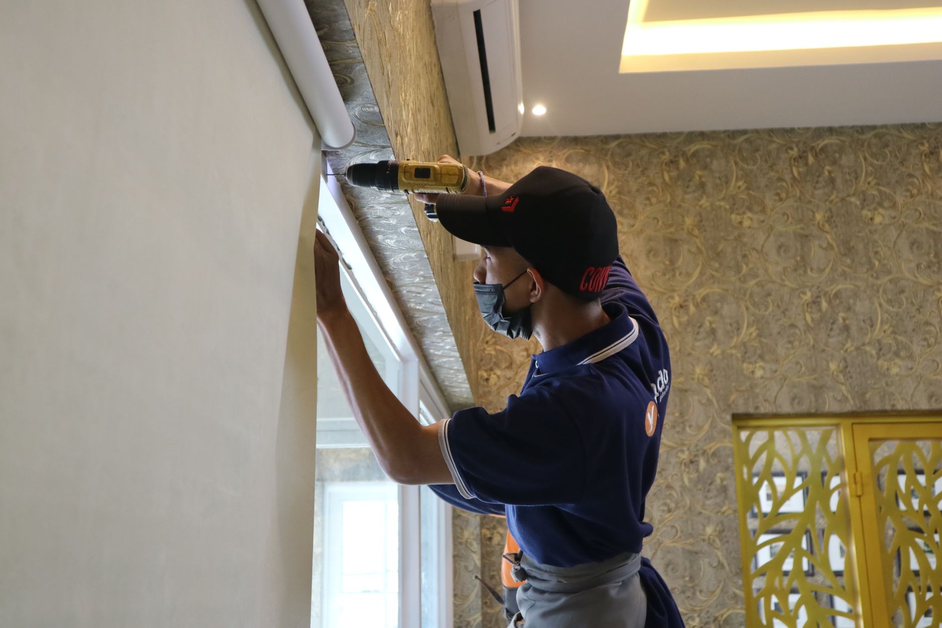 A Coolworks technician installing a wall-mounted aircon unit in a Singapore home