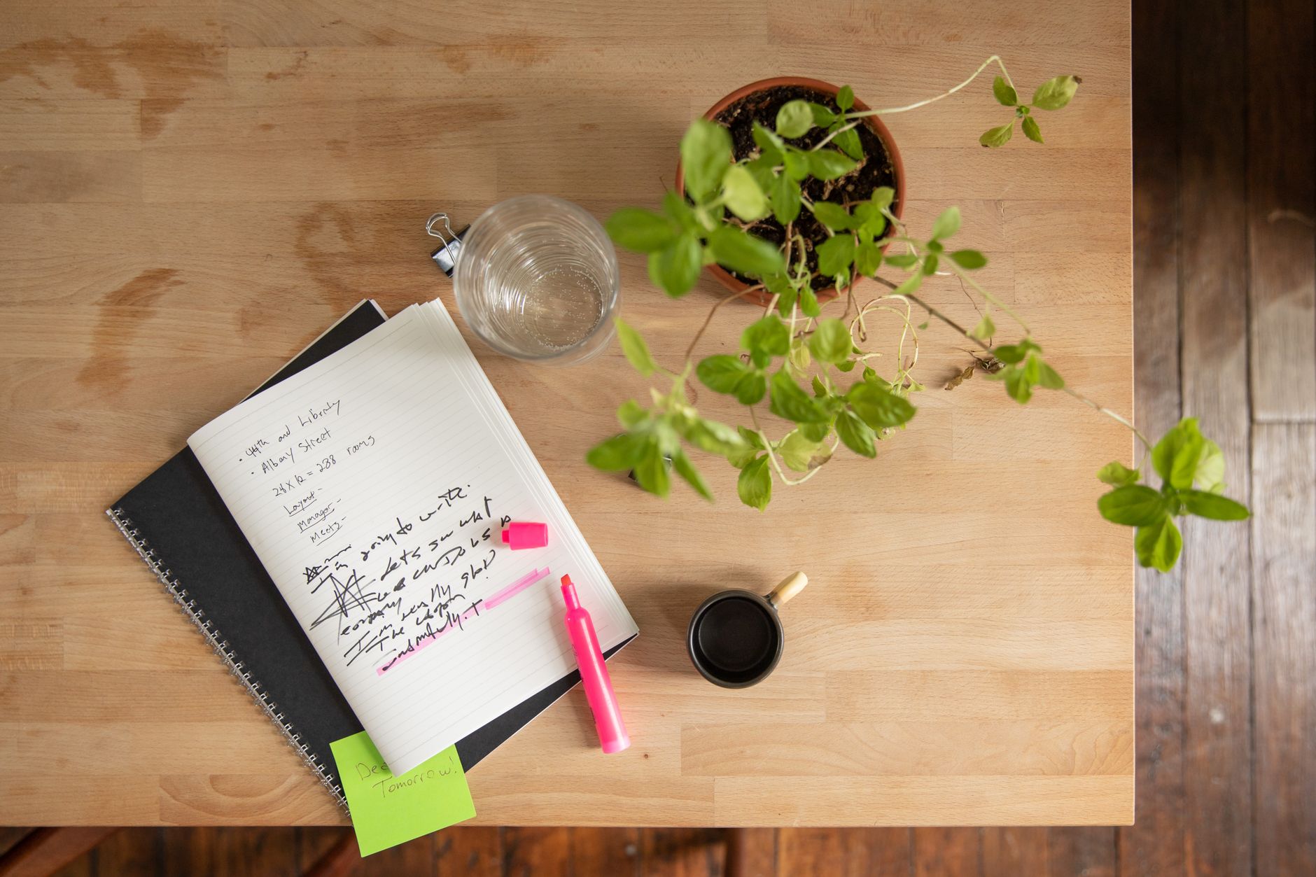 A writing desk with notebook and coffee