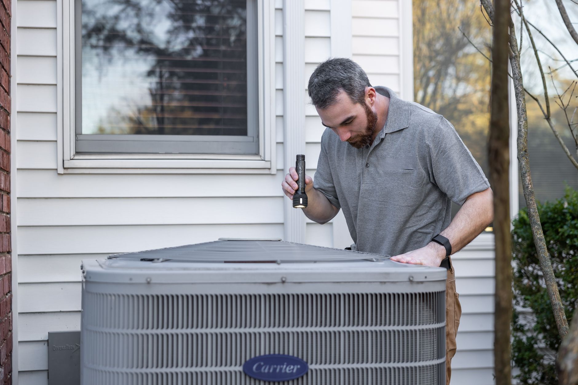 A Frostline technician servicing an air conditioner in a Singapore home