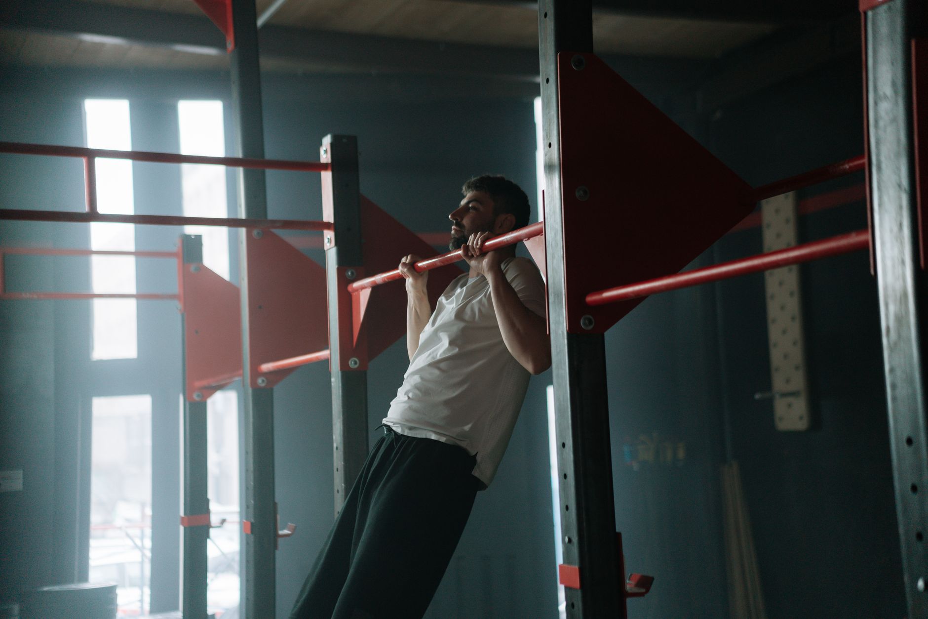 An athlete pulling into a muscle-up on a calisthenics bar — bodyweight strength training in Singapore
