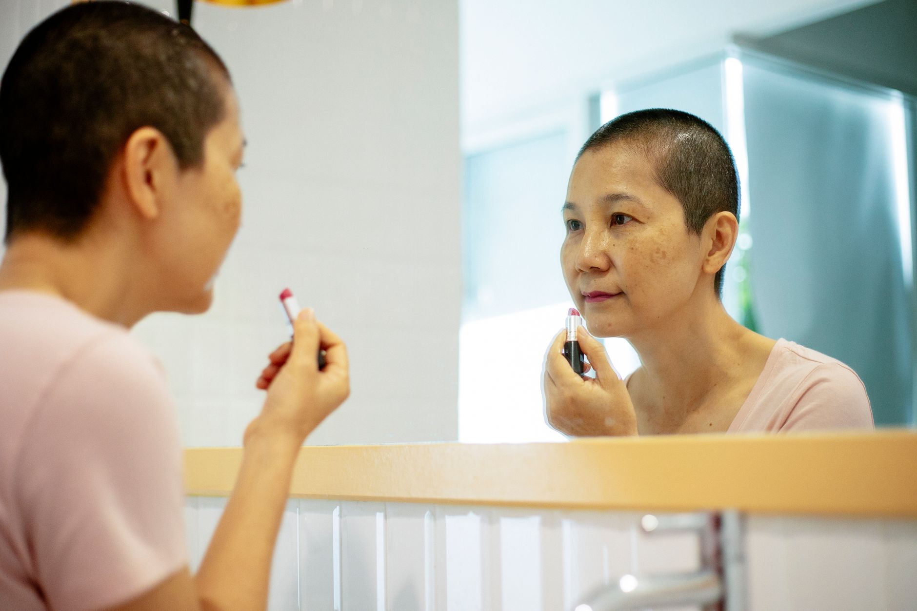 Woman applying Inara lip colour at a mirror