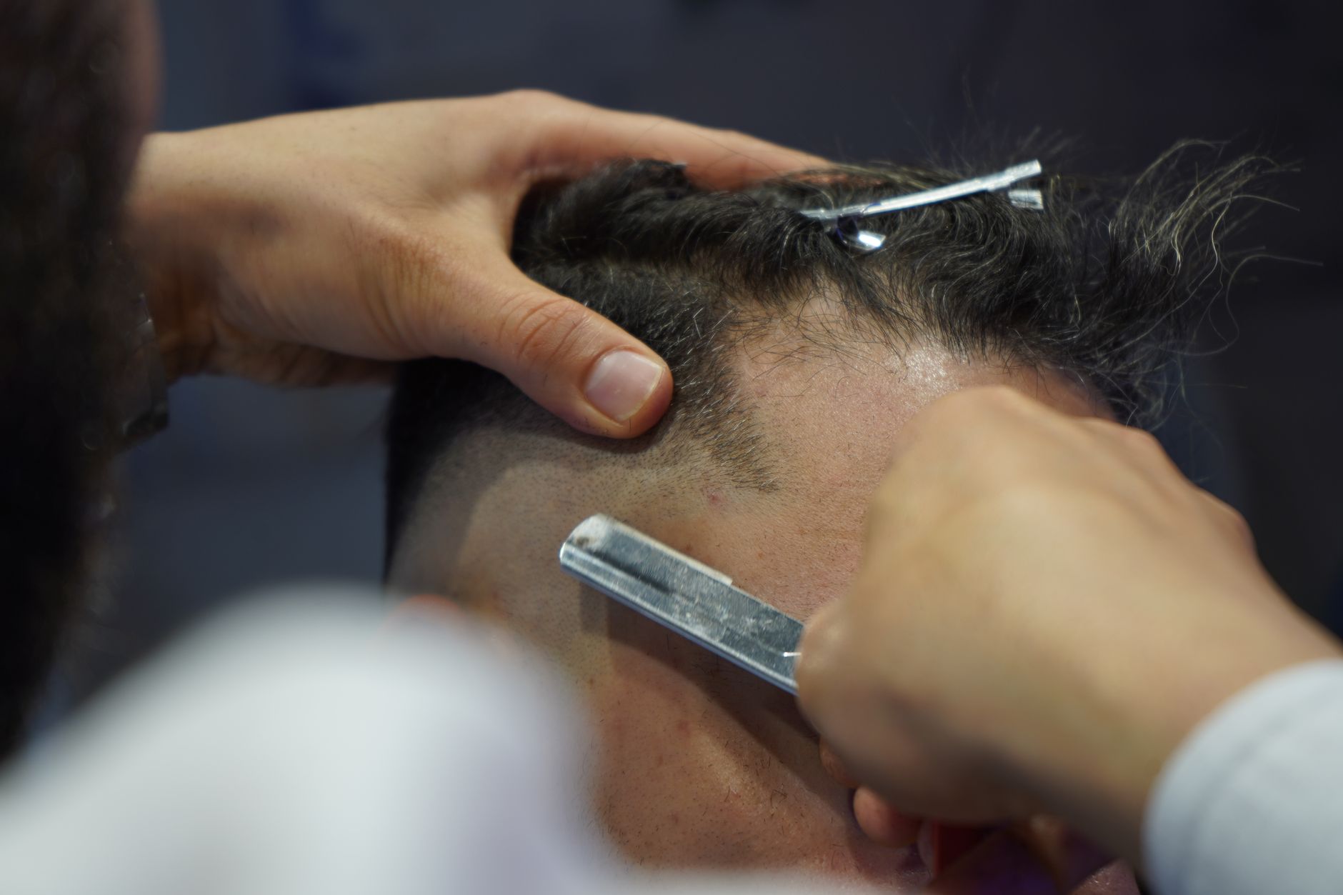 A barber cutting a man's hair in the Ironside barbershop on Tras Street, Singapore