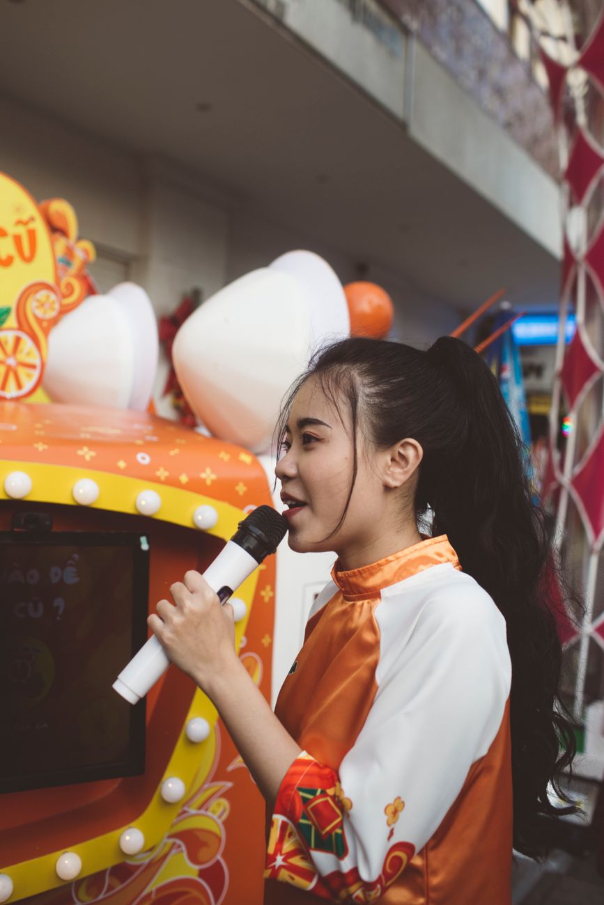 A vocalist singing into a microphone at an event