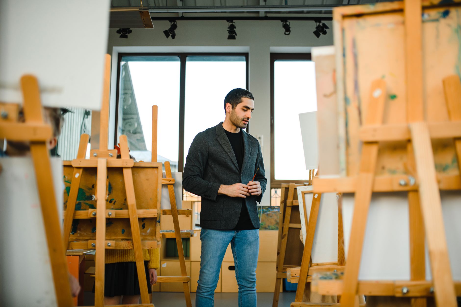 Students at easels in a bright art studio