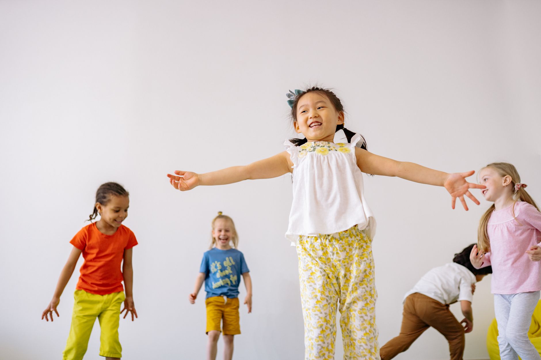 Children leaping and laughing in a fun dance class