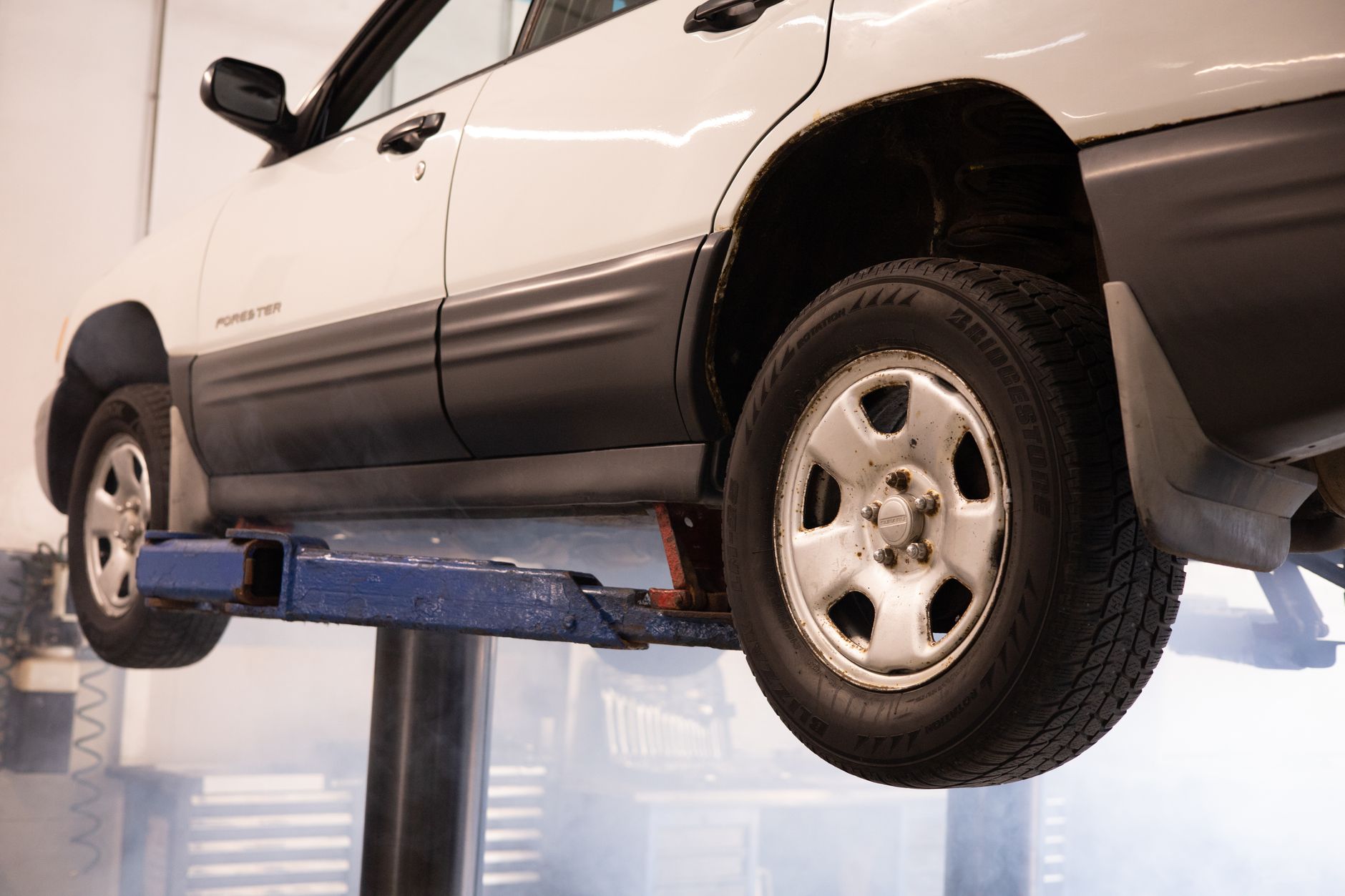 A car raised on a two-post lift inside Revline Garage's Sin Ming workshop in Singapore