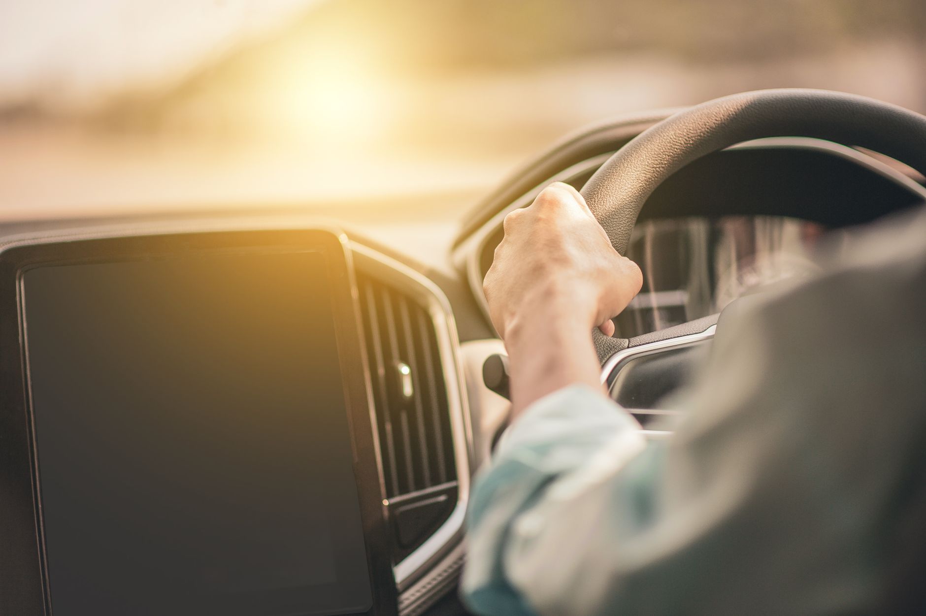 A driver behind the wheel of a Roadster Rentals self-drive hire car on a Singapore road