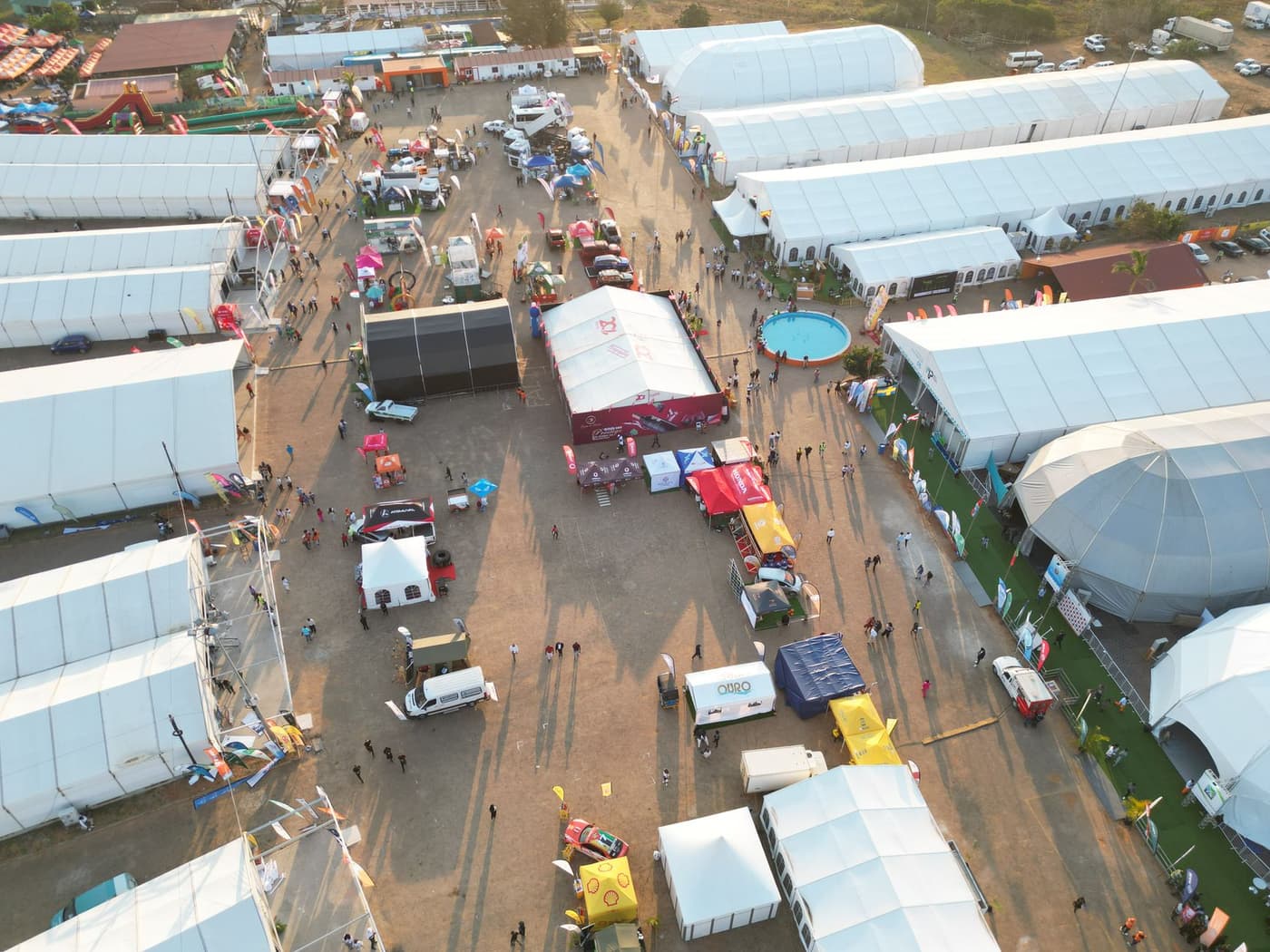 A busy exhibition hall full of custom-built stands and overhead lighting