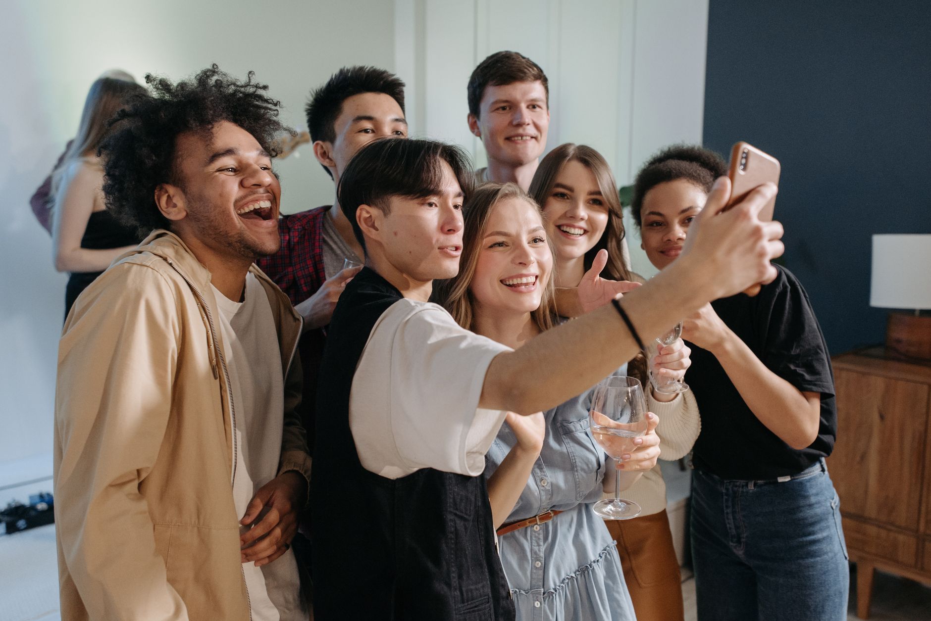 Party guests laughing with props in front of a backdrop