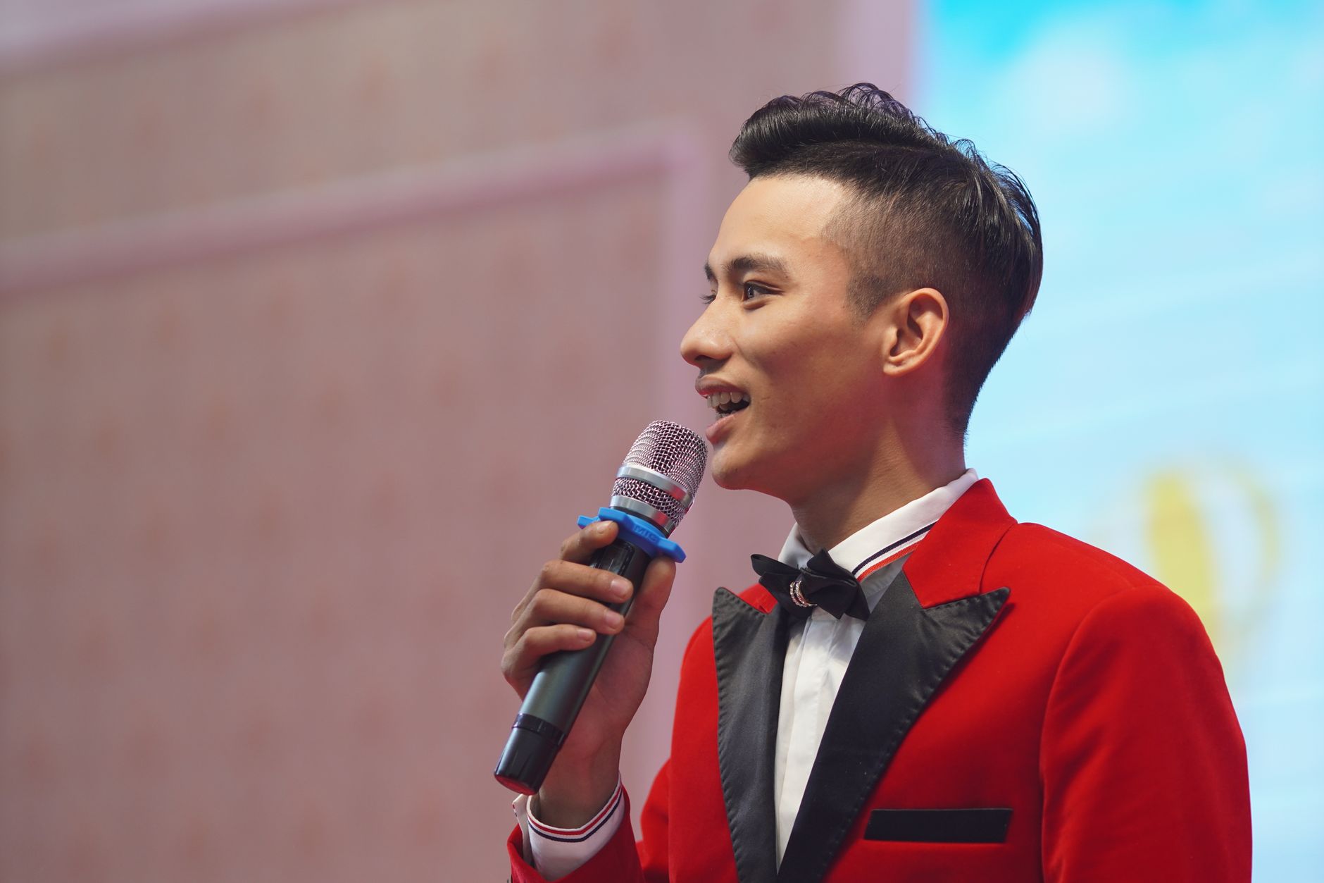 Sufyan Halim hosting an event with a microphone